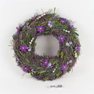 Paarse decoratieve bloemenkrans met natuurlijke gedroogde takjes en kunstbloemen feest.