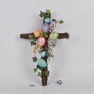 Easter twig cross wreath with colorful glitter eggs, artificial leaves and berries for spring decor.