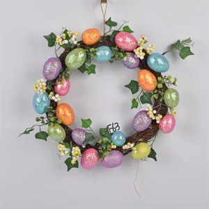 Close-up detail of Easter wreath featuring colorful glitter eggs, green leaves, and twig base.