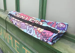 Detailed close-up of a colorful graffiti printed long fin diving backpack with shoulder strap.