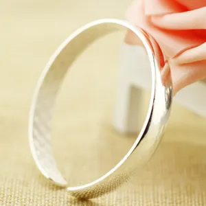 Primo piano di un bracciale rigido vintage placcato in argento con finitura lucida.