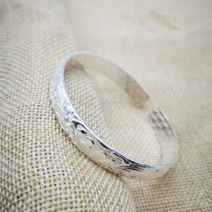 Primo piano di un bracciale rigido aperto placcato in argento in stile vintage