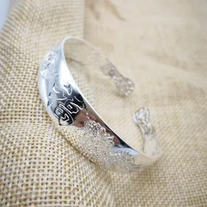 Primo piano di un bracciale rétro placcato argento con incisione di drago e carattere Fu.