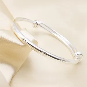 Primo piano di bracciale vintage argentato con caratteri Fu incisi e design regolabile