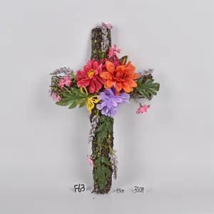 Easter cross twig wreath hanging decoration with colorful artificial flowers and green leaves