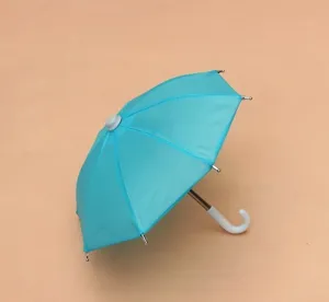 Miniature blue toy umbrella, cute dollhouse accessory and creative photography prop for kids.