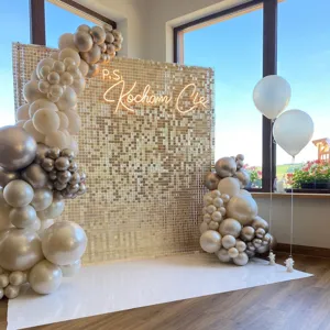 Detailed view of the gold shimmer wall backdrop with elegant balloon arch for party decoration.