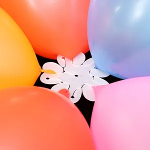 Detail view of white plastic plum blossom balloon clip connector for party arch decor setup.