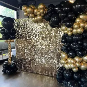 Kit d'arche de ballon noir et or avec fond de mur de paillettes scintillantes pour la fête.