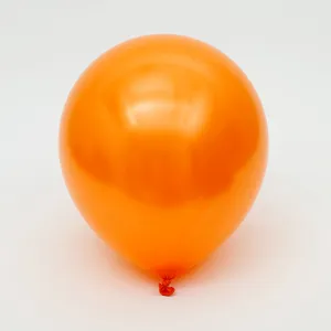Détail de ballon en latex nacré orange, élément déco brillant pour fêtes et événements.