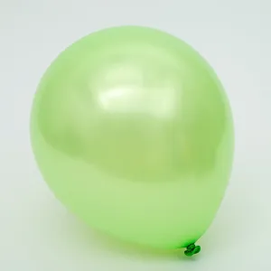 Gros plan d'un ballon en latex nacré vert clair, présentant une surface brillante et lisse.