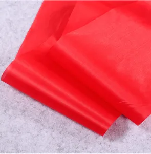 Detailed view of the bright red satin fabric, showing smooth texture and glossy surface.