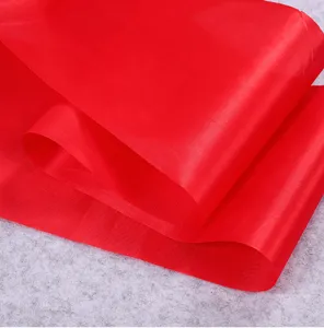 Bright red satin fabric roll for festive decoration, ribbon crafting, and celebrations.