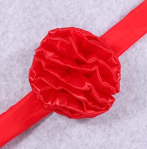 Red satin ribbon flower detail closeup, glossy fabric for celebration ribbon cutting events.