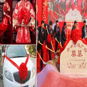 Red silk ribbon and large decorative fabric flower set for wedding ceremonies and ribbon cutting.
