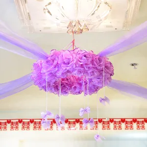 Wedding decoration purple flower wreath with tulle sheer fabric and pearl hanging bows for indoor setup.
