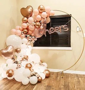 Detail shot of golden metal round hoop balloon arch stand with pink and white balloons setup.