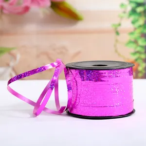Close-up detail shot of shiny pink laser ribbon roll for party and balloon decoration.