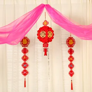 Pink sheer fabric drape with red hanging lanterns for Chinese wedding room scene setup.