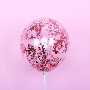 Close-up detail of clear Bobo balloon filled with red confetti sequins and white stick.