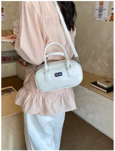 Detail shot of white bowling shoulder bag with metal plaque, casual fashion women accessory