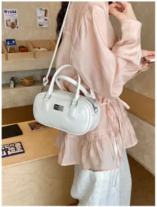 Vintage solid color bowling shoulder handbag for women, casual crossbody bag with metal badge.