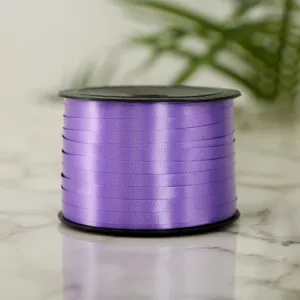 Closeup view of a purple plastic balloon ribbon spool for gift wrapping and party decor.