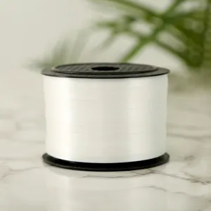Close-up detail of white plastic balloon ribbon roll for gift wrapping and party decor.