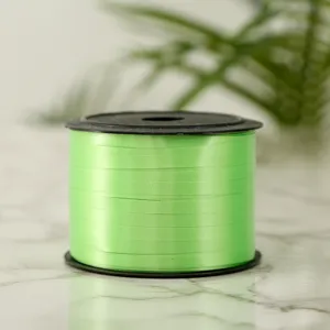 Green plastic balloon ribbon spool detail, perfect for gift wrapping and party decoration.