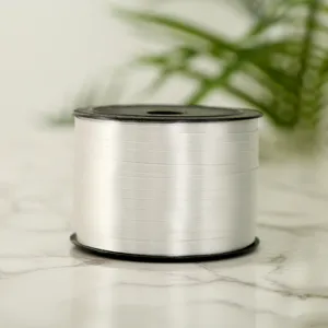 Close-up detail of white plastic ribbon spool for balloon and gift wrapping decoration.