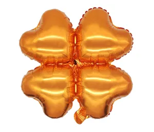 Orange four-leaf clover foil balloon detail, metallic orange finish, close-up shot.