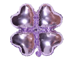 Purple four-leaf clover foil balloon detail shot, shiny metallic party decoration.