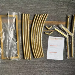Metal arch kit spare parts flat lay, golden iron tubes and frame components for party decor.