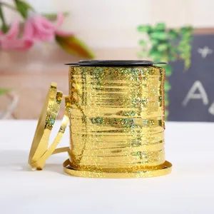 Gold holographic ribbon spool for balloon string and wedding party decorations. Detail view.