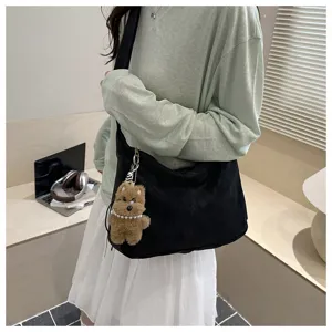 Vue détaillée du sac porté épaule noir décontracté pour femme avec charmant pendentif.