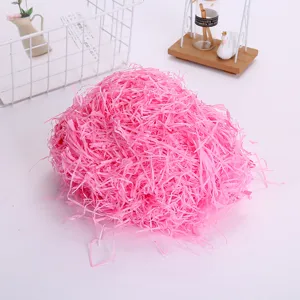 Pink shredded paper filler for gift boxes, raffia grass packing material for hampers and crafts.