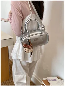 Detailed view of the stylish silver bowling shoulder bag featuring a cute bear pendant.