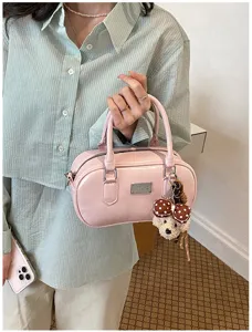 Pink bowling handbag detail view, retro casual women crossbody bag with cute bear pendant.