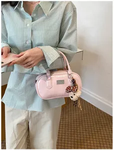 Pink patent leather bowling bag detail shot with cute bear charm and metal buckle hardware.