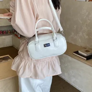 Vintage solid color bowling bag for women, stylish leather shoulder and crossbody handbag.