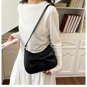 Detail shot of stylish black hobo shoulder bag featuring a chic bow accent and minimalist design.