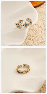 Gold-plated open ring featuring intricate cross patterns and turquoise details, close-up jewelry shot.
