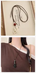 Long beaded sweater chain necklace with adjustable black cord and natural stone pendants.