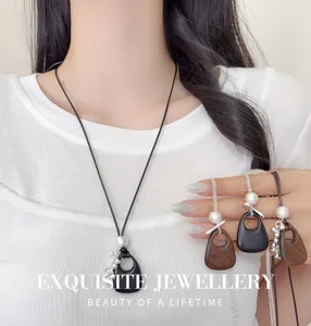Detail view of Korean style wooden cutout teardrop pendant necklace with pearl and metal decor.