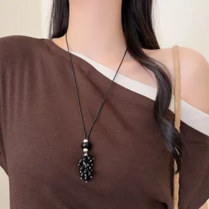 Elegant black beaded long sweater necklace with black cord and metal accents for women.