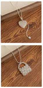 Detailed view of Korean style silver heart necklace and beaded bag pendant for elegant daily wear.