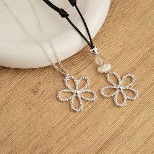 Korean ins style silver hollow flower pendant necklace with black cord and metal chain.
