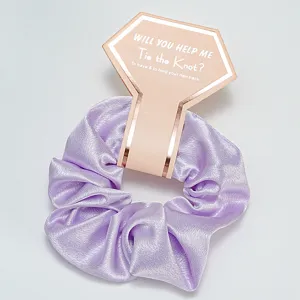 Chouchou en satin lavande emballé dans une carte cadeau pour demoiselle d'honneur