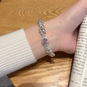 Bracelet de perles exquis avec un centre en pierre rose et des accents de zircon étincelants.