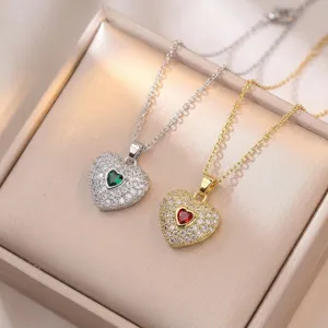 Vue rapprochée des colliers pendentifs cœur en argent et or avec des pierres zircon scintillantes.